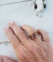 Wearing copper coil ring with white distressed wood background