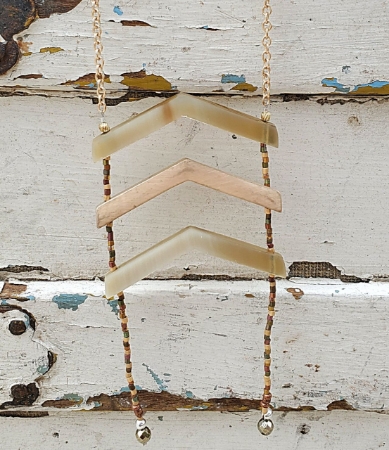 neutral colored Chevron necklace on white wood