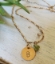 Gold initial charm chain necklace green gemstones on rock