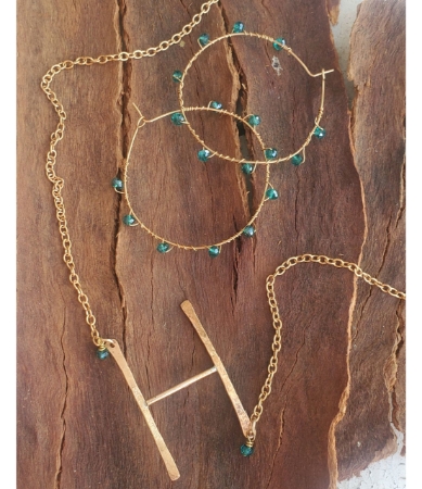 bronze letter h and crystal eternity hoops on wood 