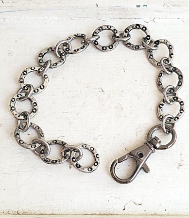 silver textured link bracelet with extra big clasp on white trunk