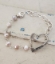 Silver open heart light pink pearl chain link bracelet on white wood
