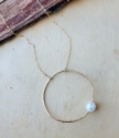 gold circle necklace with white pearl flat lay