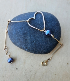 gold bar, peacock pearl, open heart bracelet on black roack