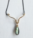 labradorite pendant gold lotus black chain close up on white