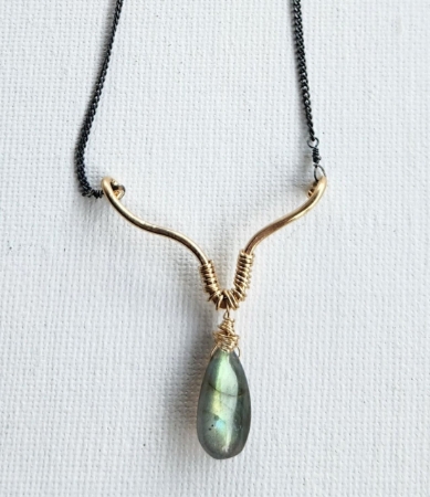 labradorite pendant gold lotus black chain close up on white