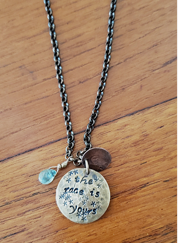 mixed metal custom coach necklace on table