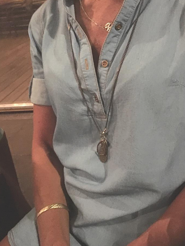 wearing long mixed metal charm necklace with denim