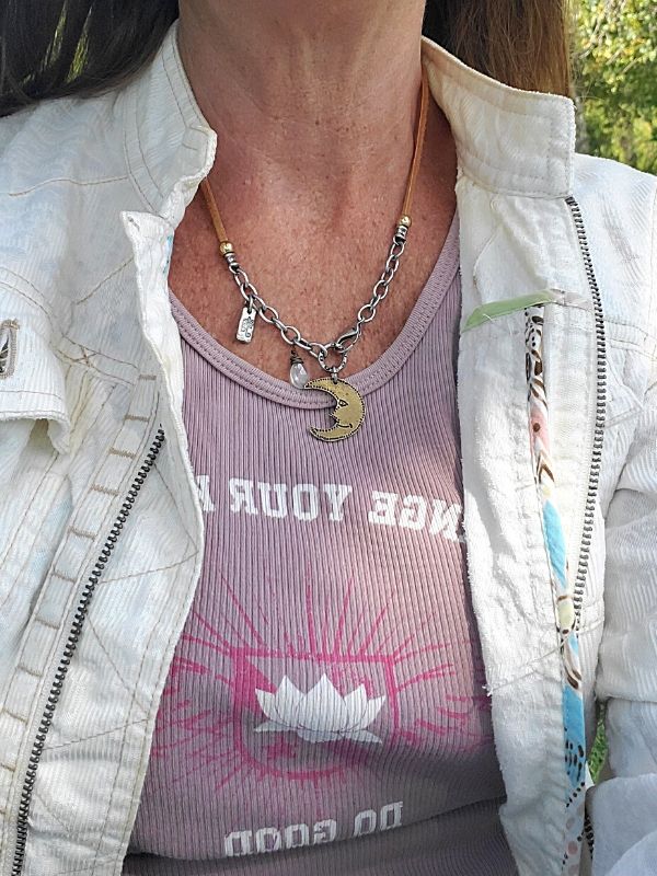 wearing a moon necklace, white jacket in the park