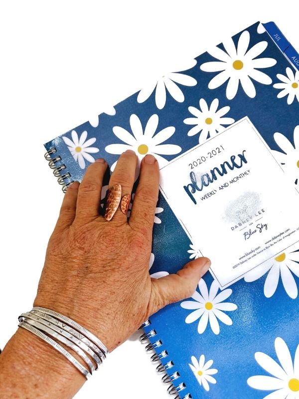 silver cuff stack on hand with planner