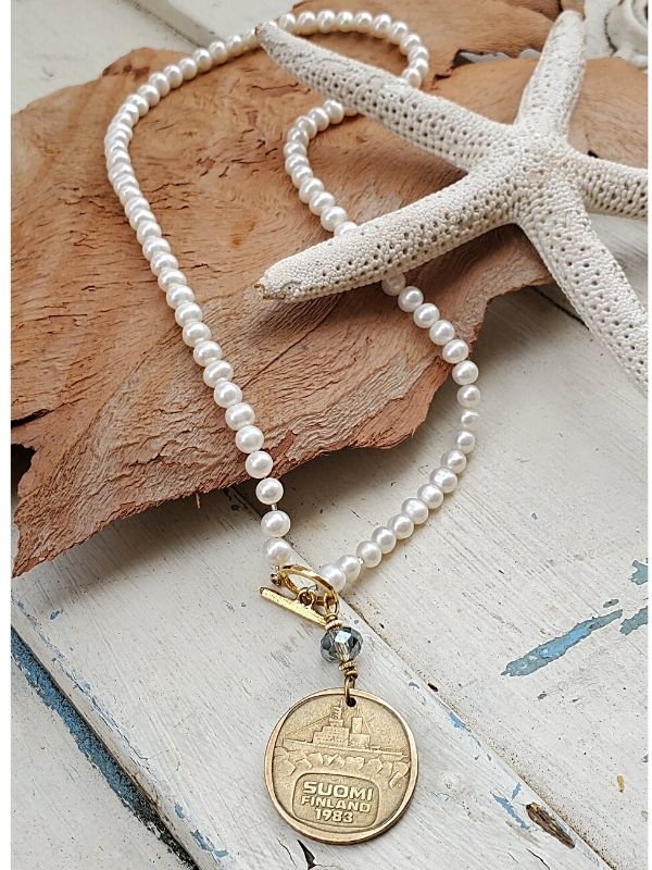 white pearl necklace on wood with starfish