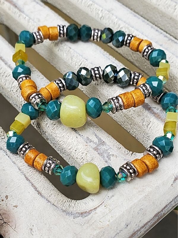 2 multi green gemstone bracelets on table