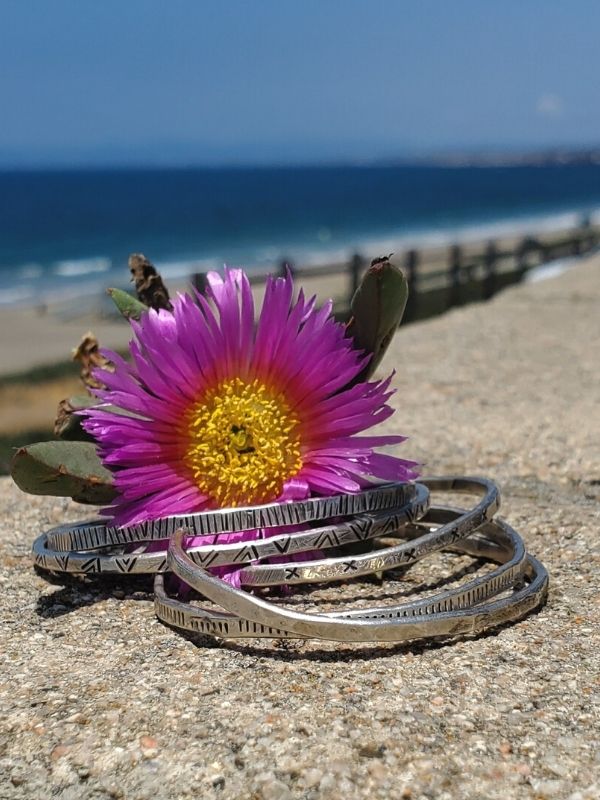 silver cuff stack on fence at beach