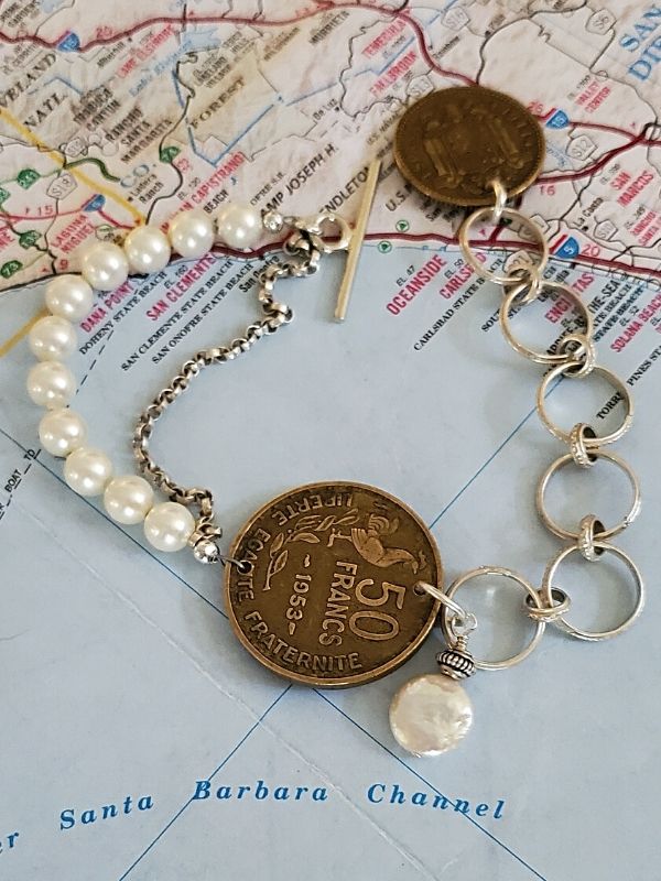 old coin bracelet on top of map