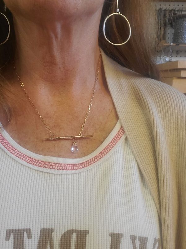 model wearing silver circle earrings & bronze bar crystal necklace