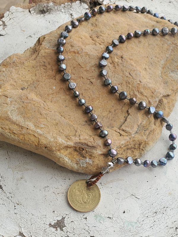 peacock blue pearl necklace on rock