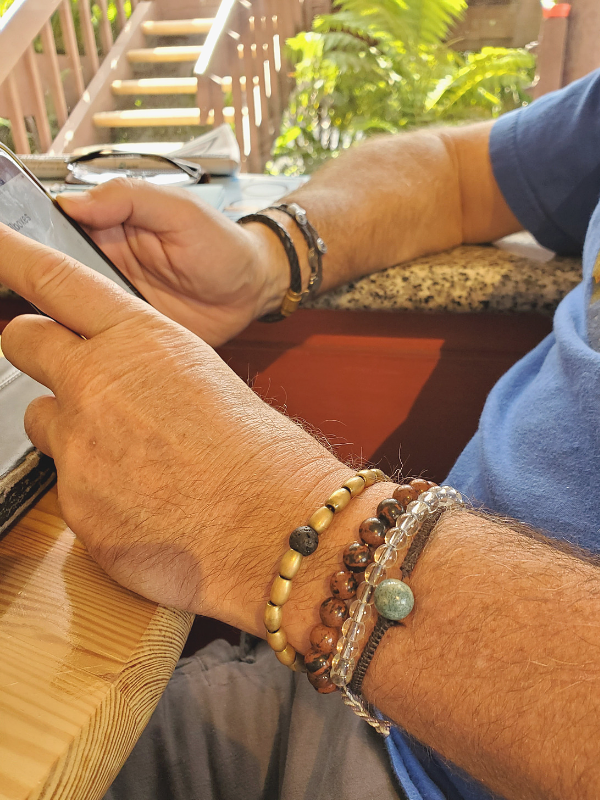 mens bracelet stack on man outside at table