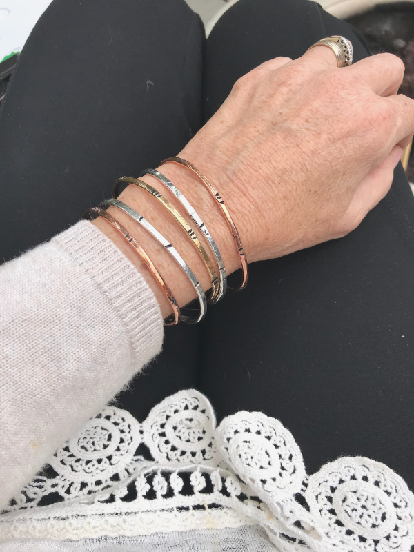 mixed metal bamboo style cuffs on tan and black outfit