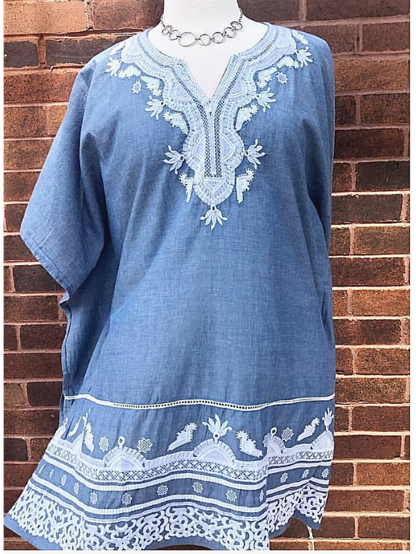 flowy denim dress with silver statement necklace against brick wall