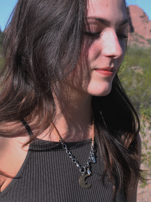 moon necklace on brown shirt model outside